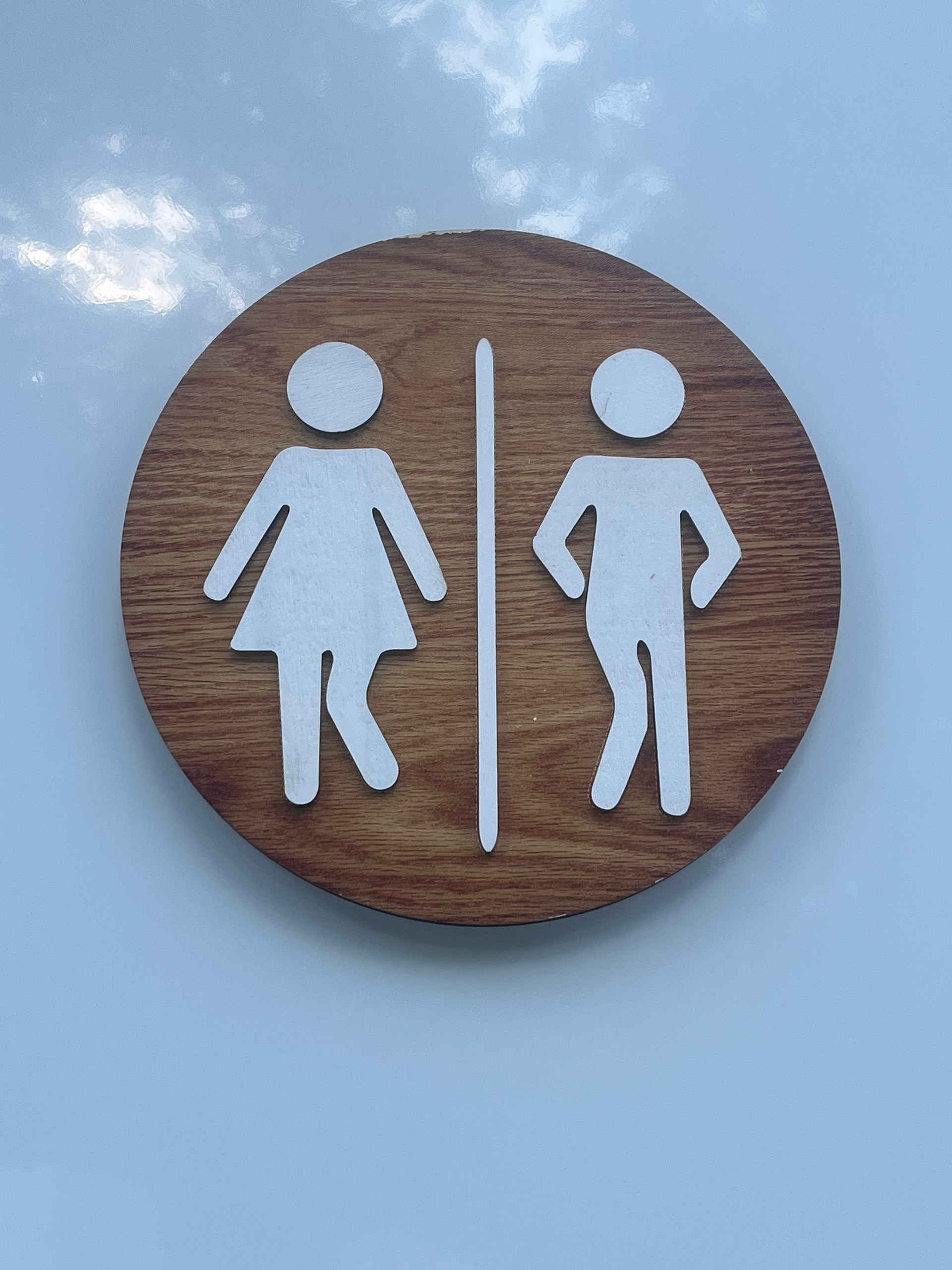 A wooden sign with a man and a woman on it
