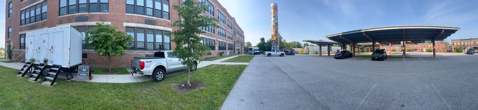 A white truck is parked in front of a brick building.