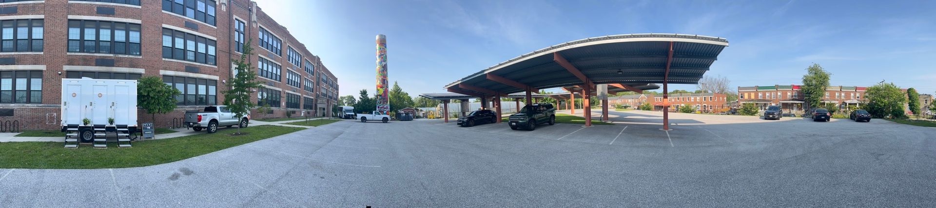 A panoramic view of a parking lot with a building in the background.