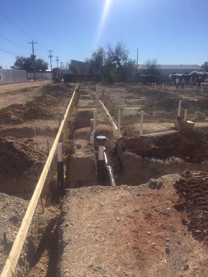 A construction site with a lot of dirt and pipes
