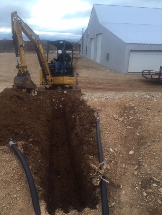 A yellow excavator is digging a hole in the dirt.