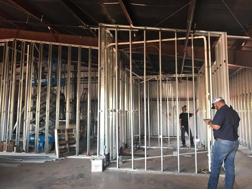 A man is standing in the middle of a building under construction