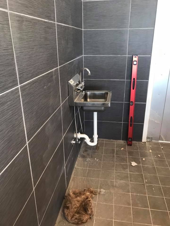 A bathroom with a sink and a red level on the floor.