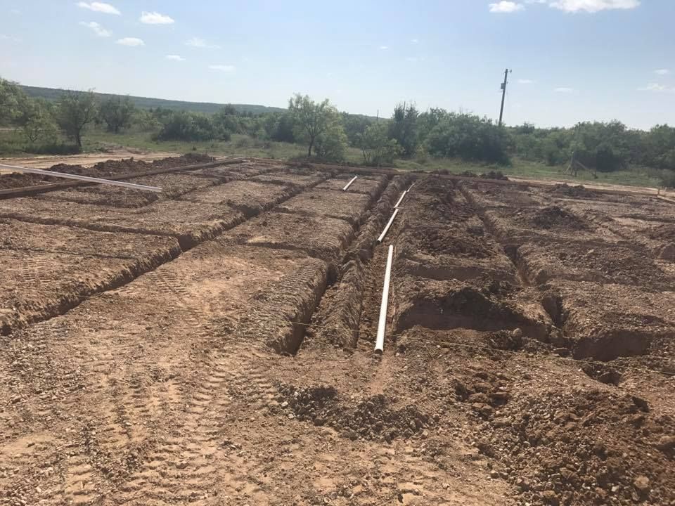 A dirt field with a pipe in the middle of it