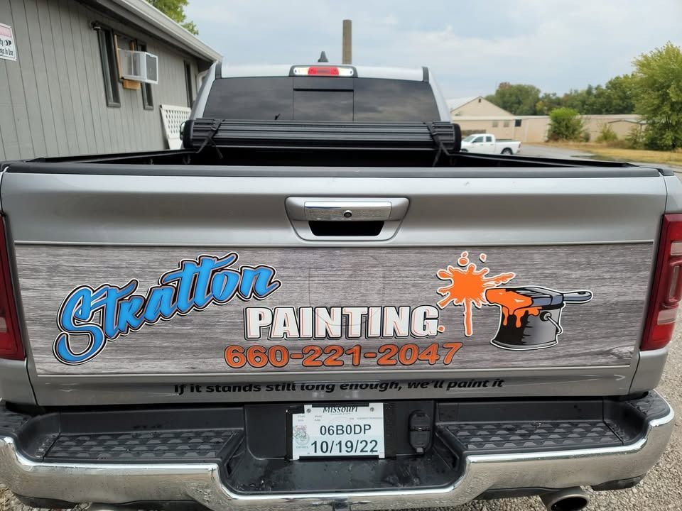 A gray pickup truck tailgate featuring a wood-grain wrap, the 