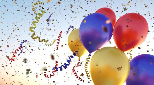 Una stanza decorata con palloncini e una torta per il primo compleanno di un bambino.