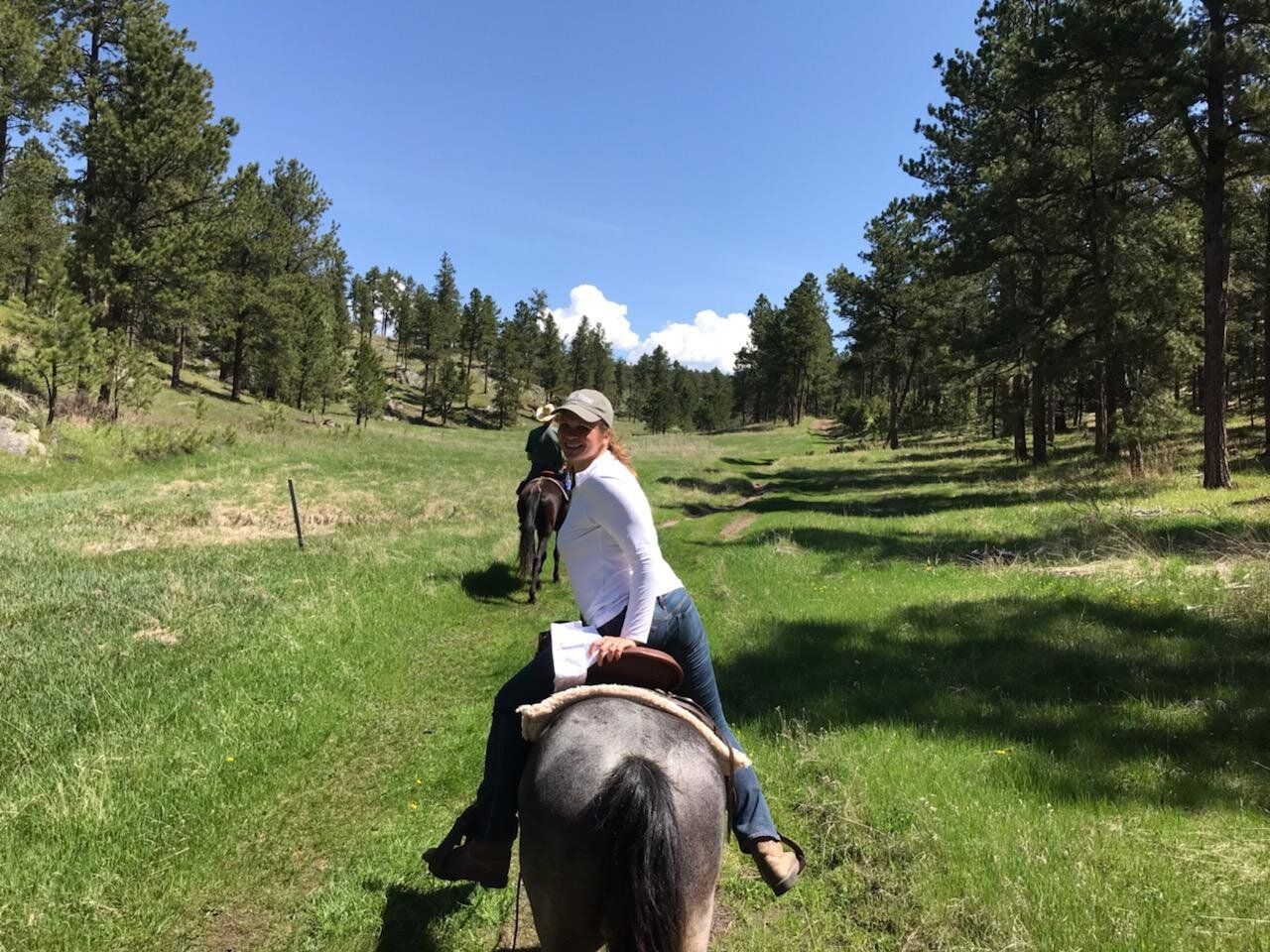 a man is riding a horse in a grassy field .