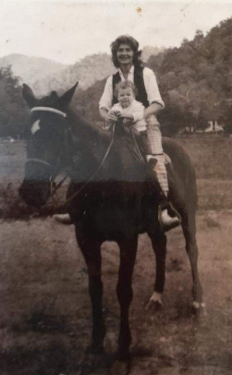 a man and a child are riding a horse in a field .