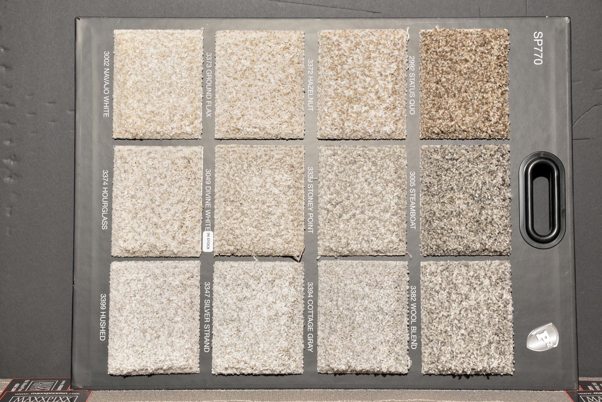 A variety of carpet samples are displayed on a black board