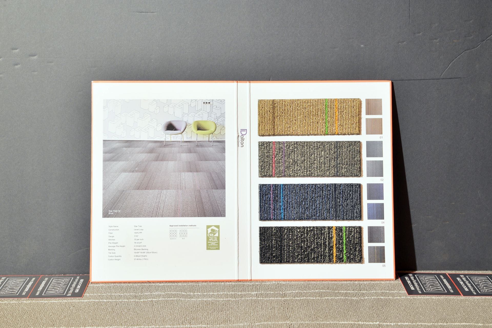 A book is open to a page showing different shades of carpet