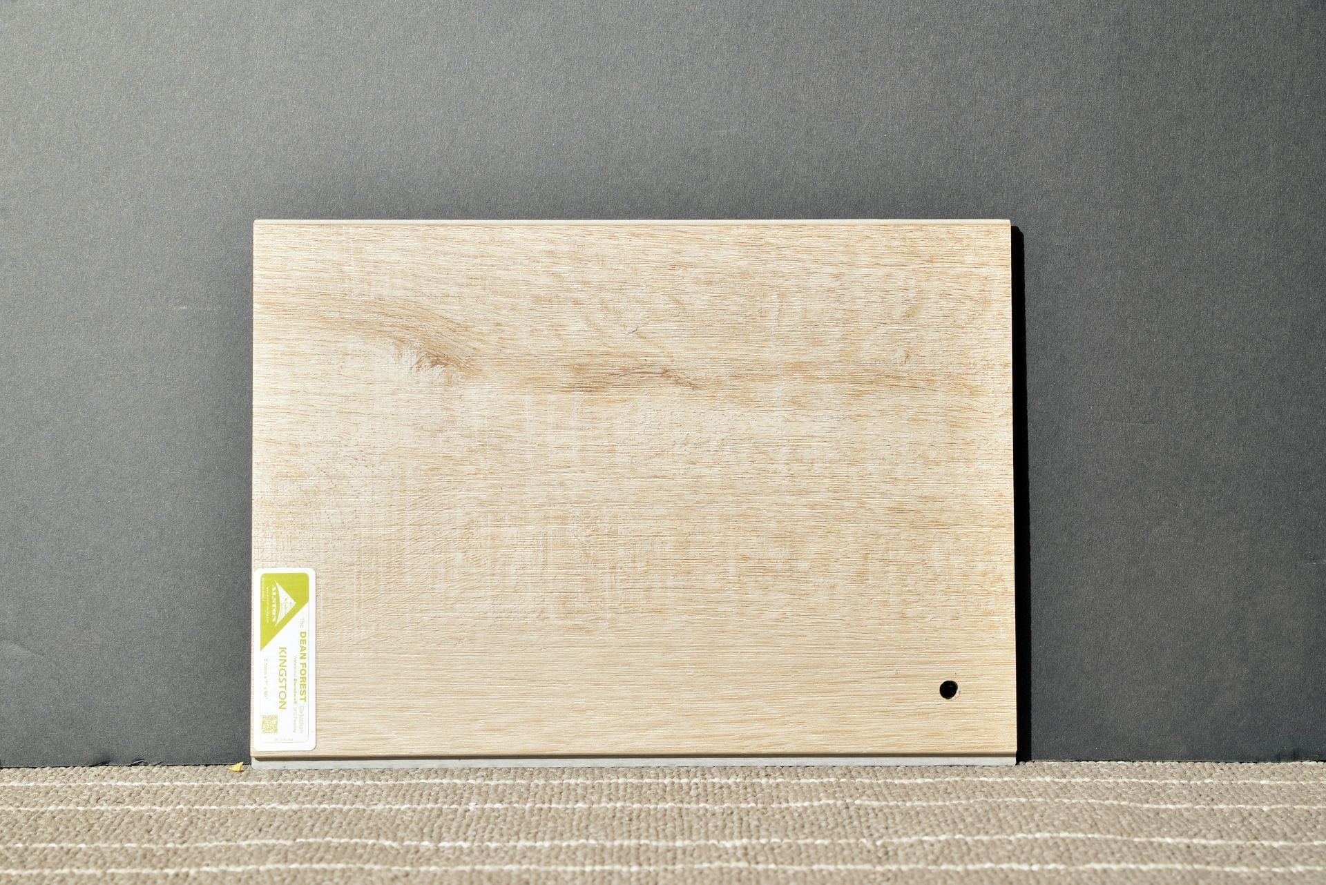 A piece of wood with a label on it is sitting on a table.