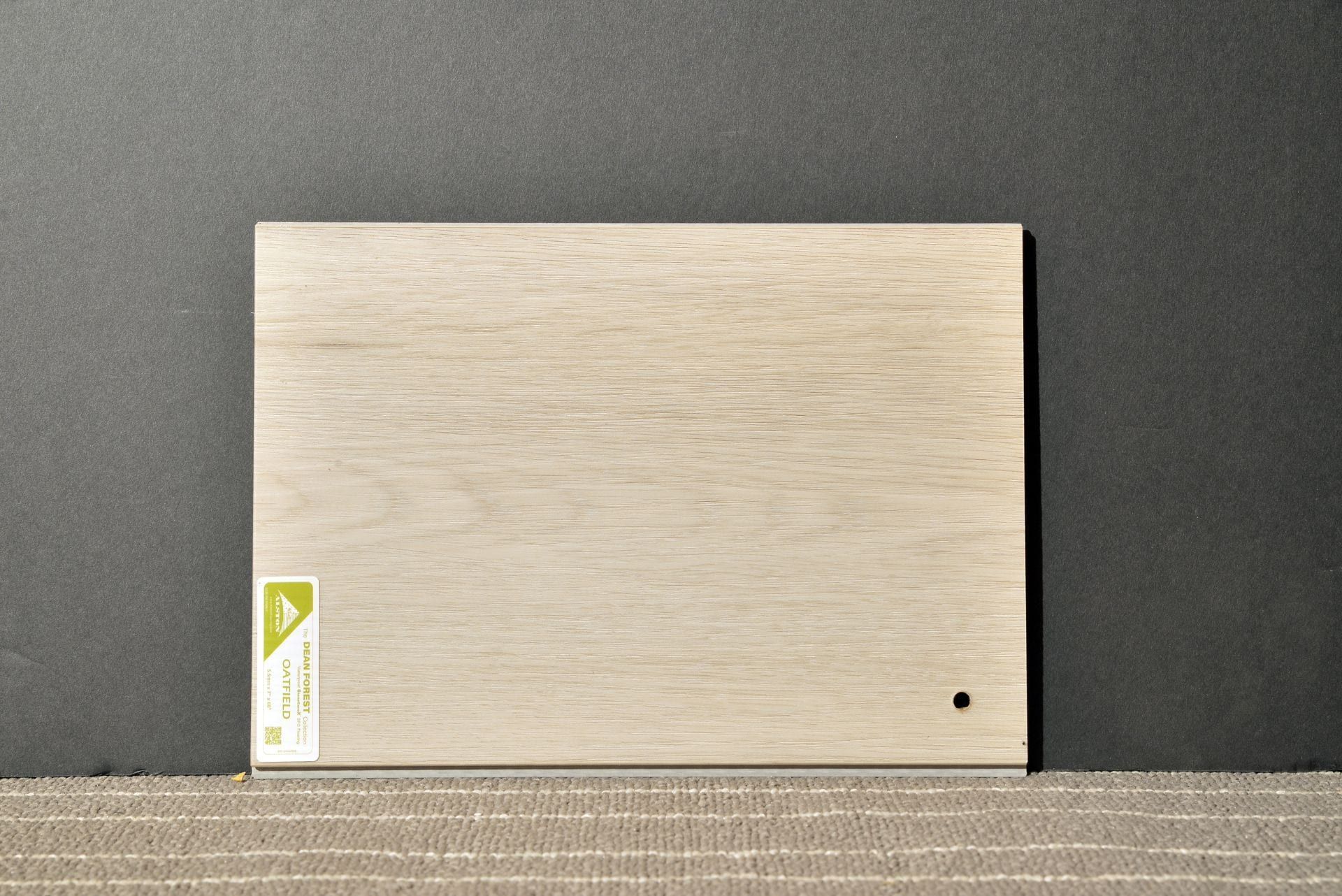 A piece of wood with a label on it is sitting on a table.