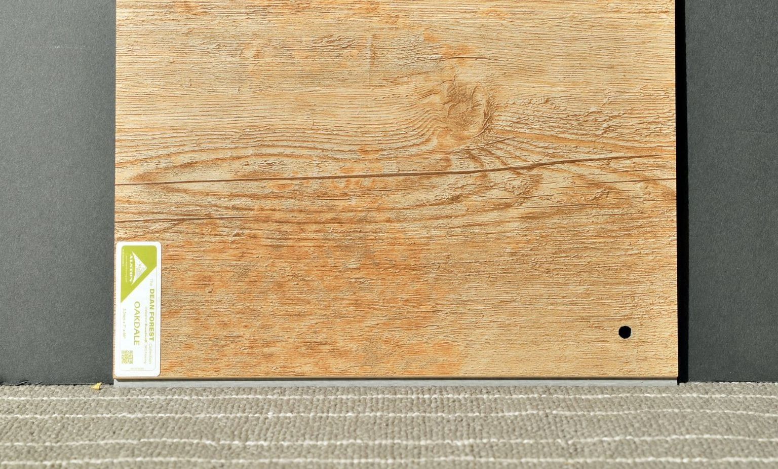 A piece of wood is sitting on top of a carpet.