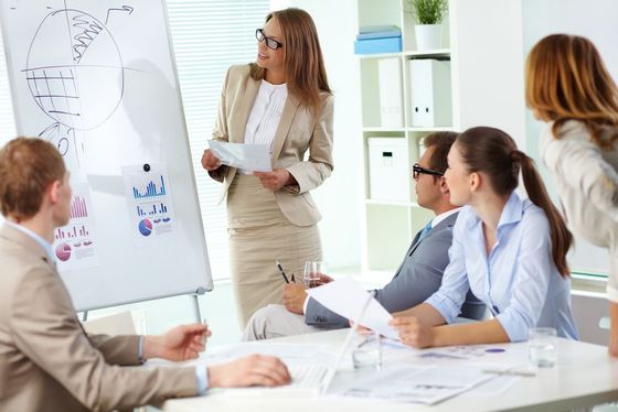 A group of people are sitting at a table in a conference room.