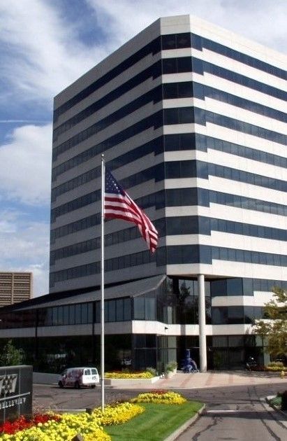 An american flag is flying in front of a tall building