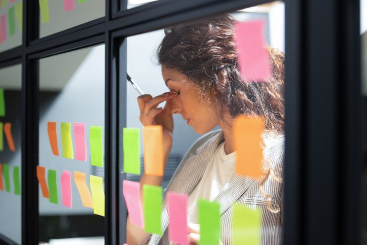 Woman business owner in front of dozens of sticky notes on the wall