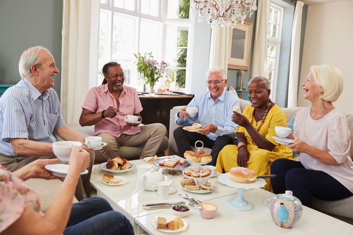 Group of seniors enjoying tea around a table