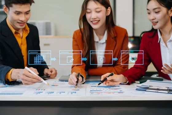 A group of people are sitting at a table in a conference room.