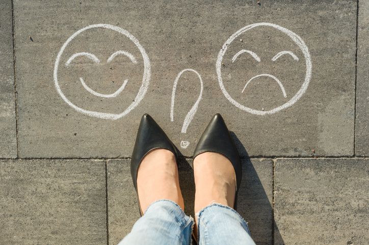 Woman looking down at her high heels on the pavement, choosing which way to go.