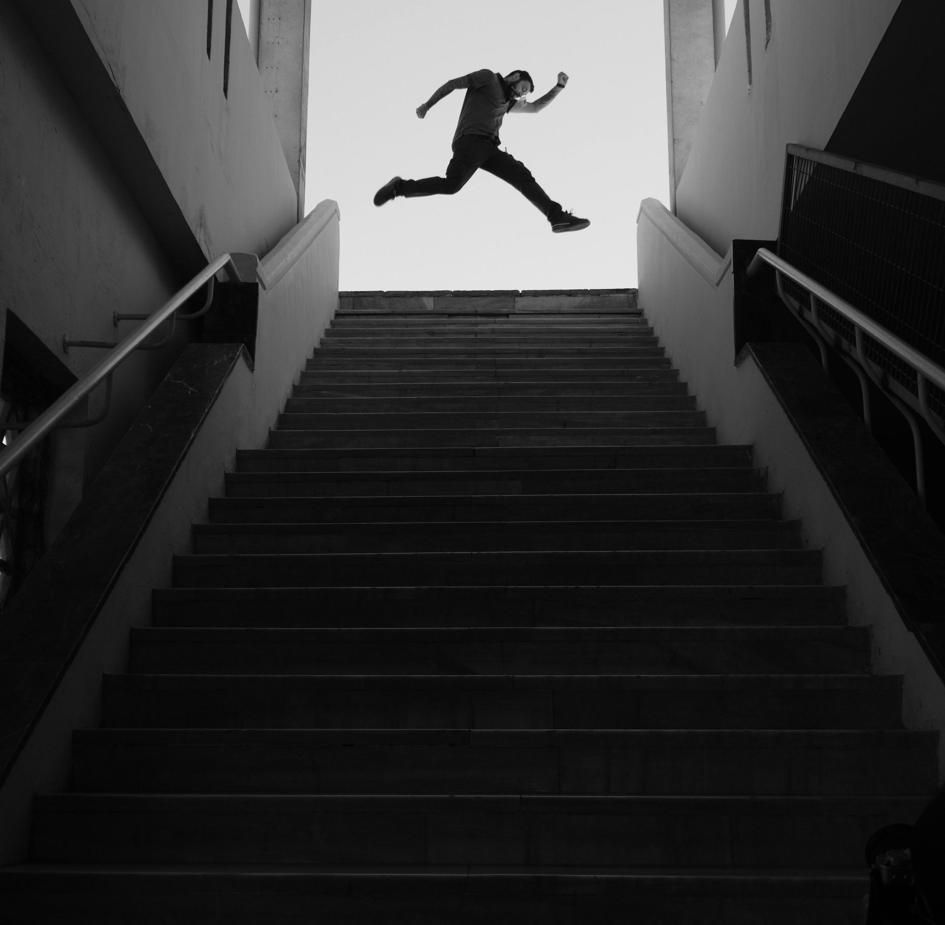 Man leaping across a wide stairway
