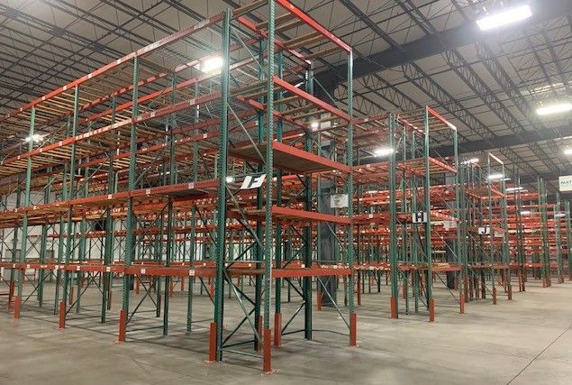 A large warehouse filled with lots of shelves and lights.