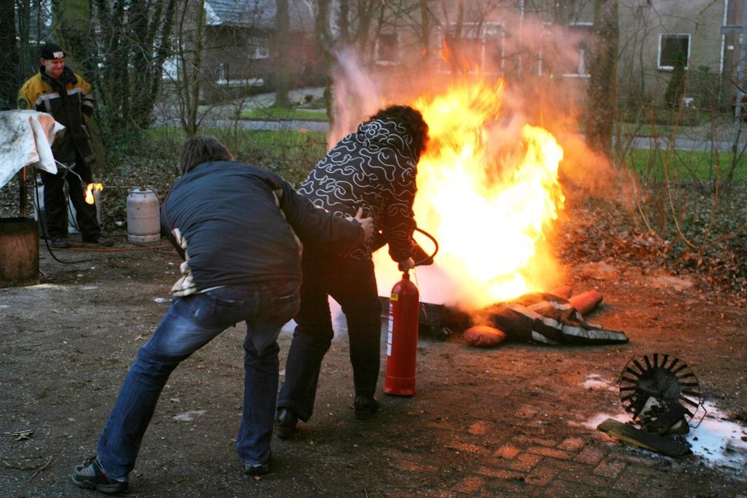 Two people are fighting a fire with a fire extinguisher