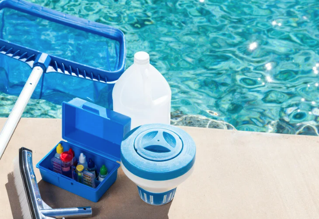 A cleaning kit is sitting on the edge of a swimming pool.
