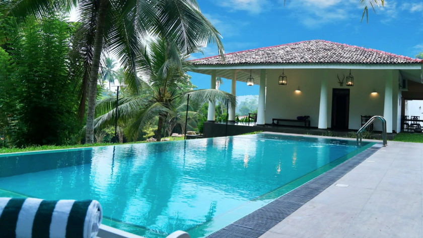 A large swimming pool with a house in the background