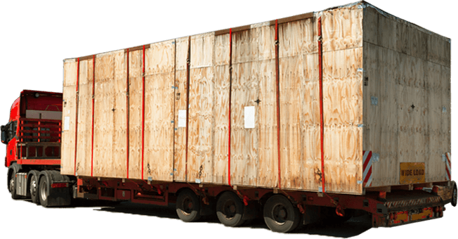 A low loader carrying a massive crate