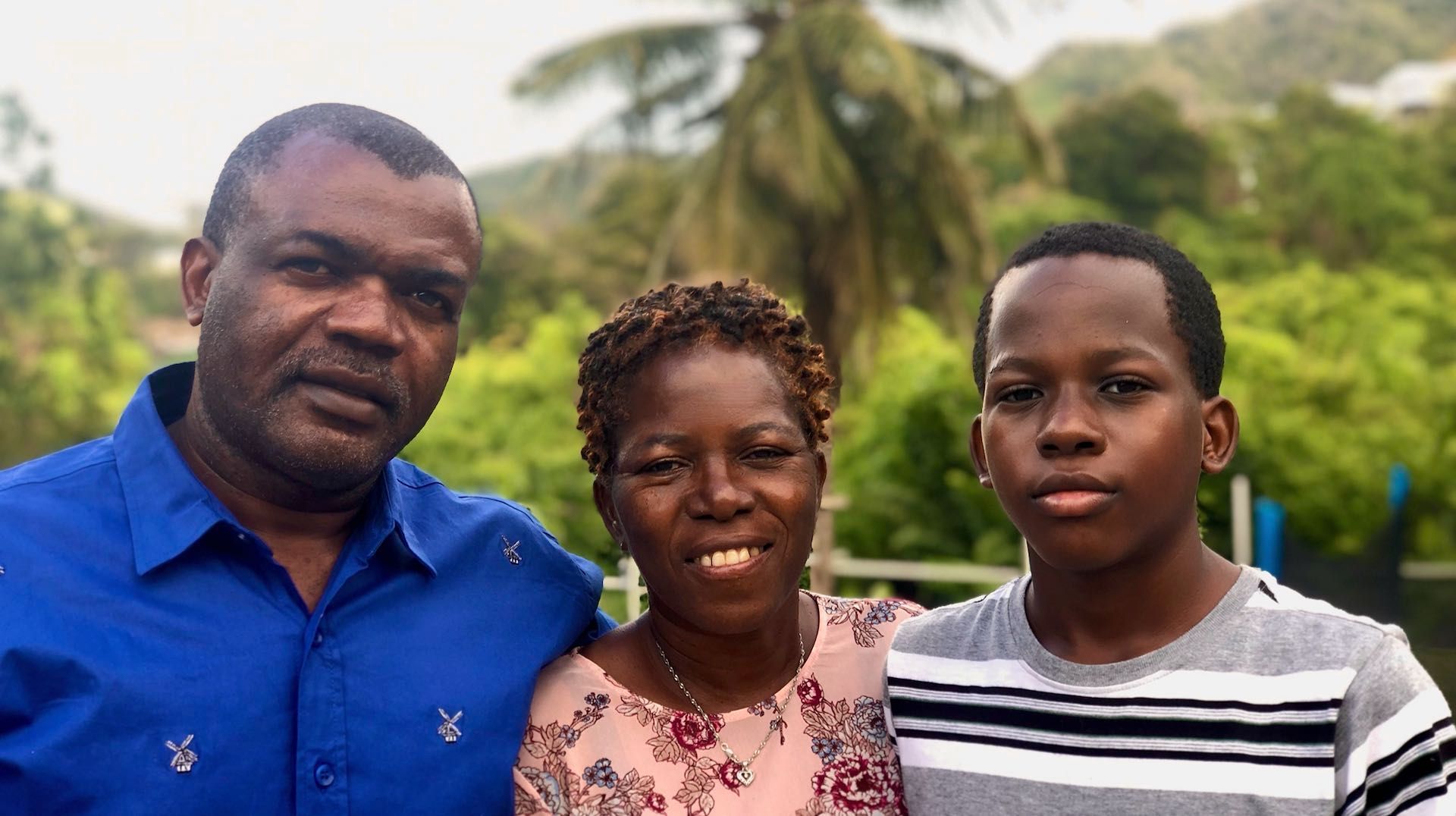A man , a woman and a boy are posing for a picture.
