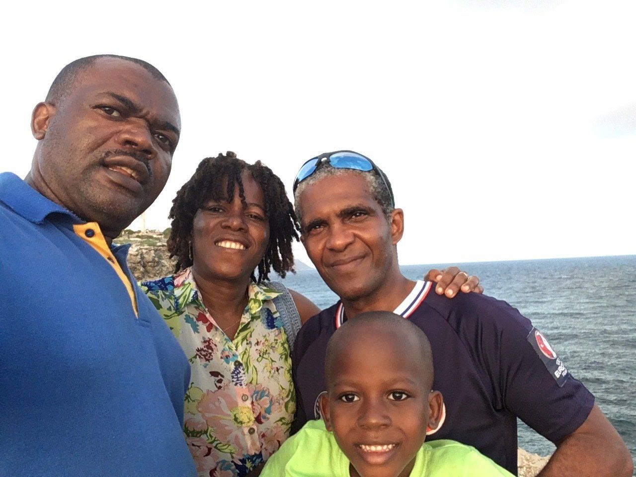 A group of people are posing for a picture in front of the ocean.