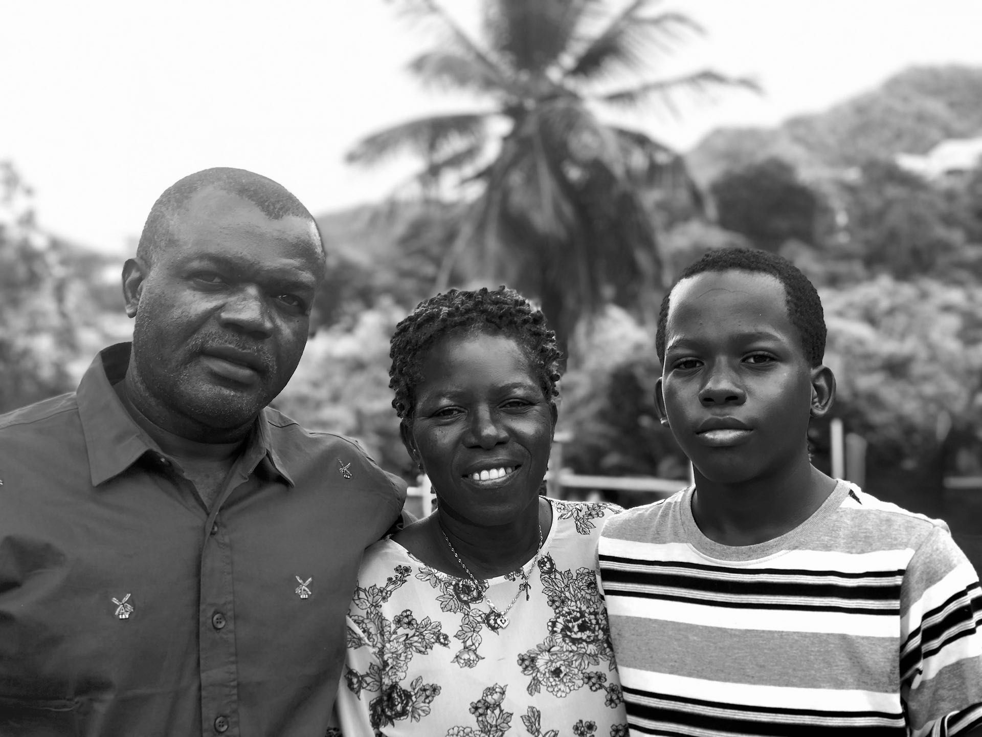 A black and white photo of a man , woman and boy posing for a picture.