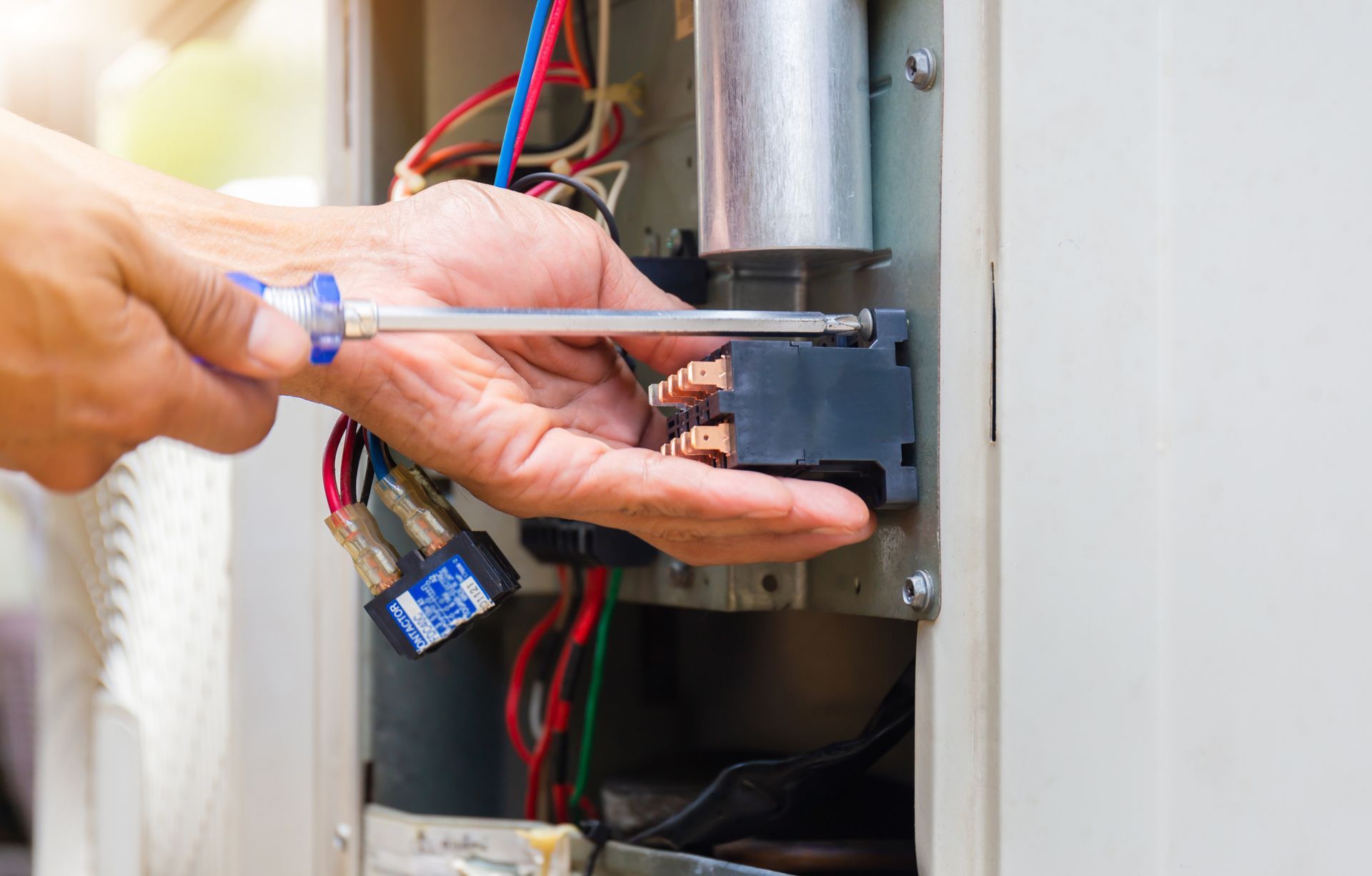 Technician wiring an electrical panel with a screwdriver