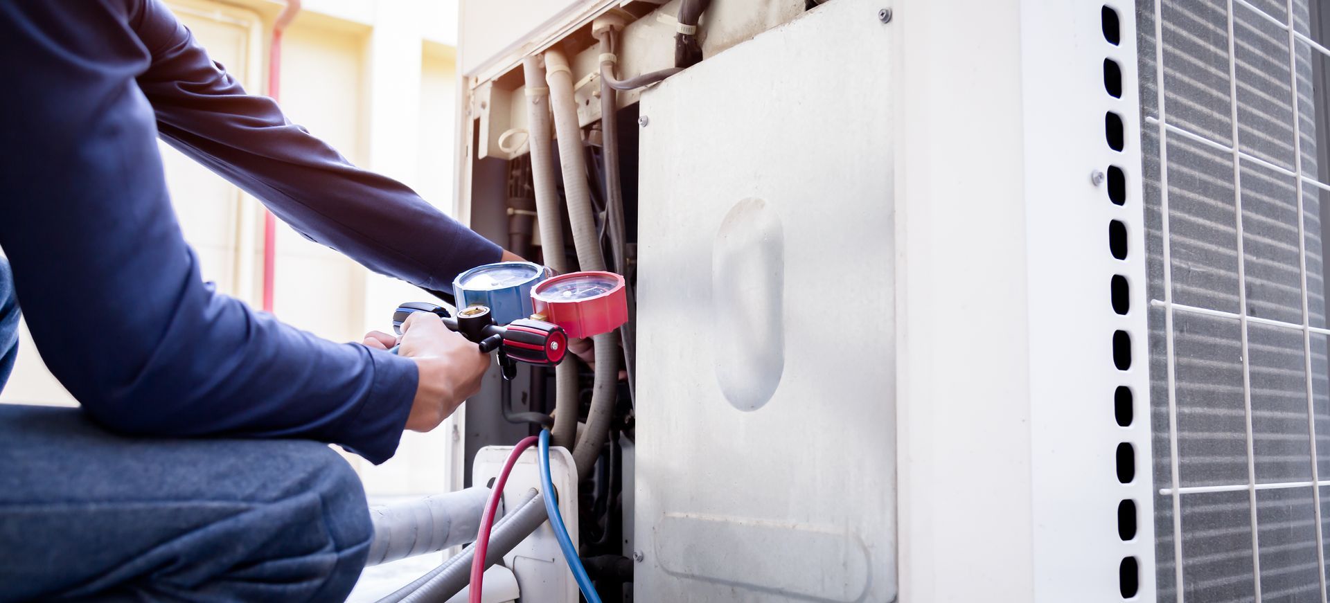Technician using a red drill to install a white appliance panel