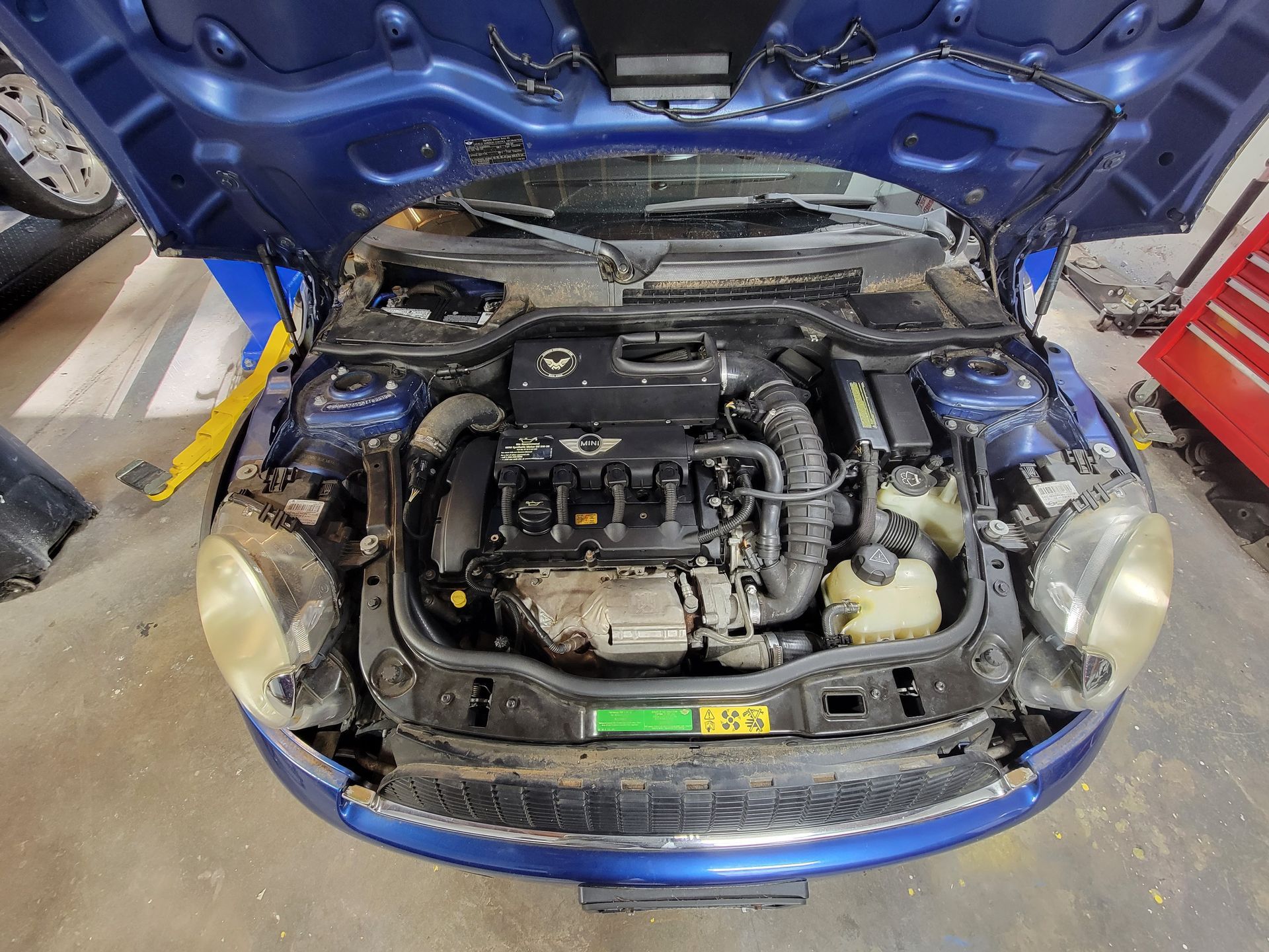 Blue Mini Cooper engine bay with the hood open. | Countryside Automotive