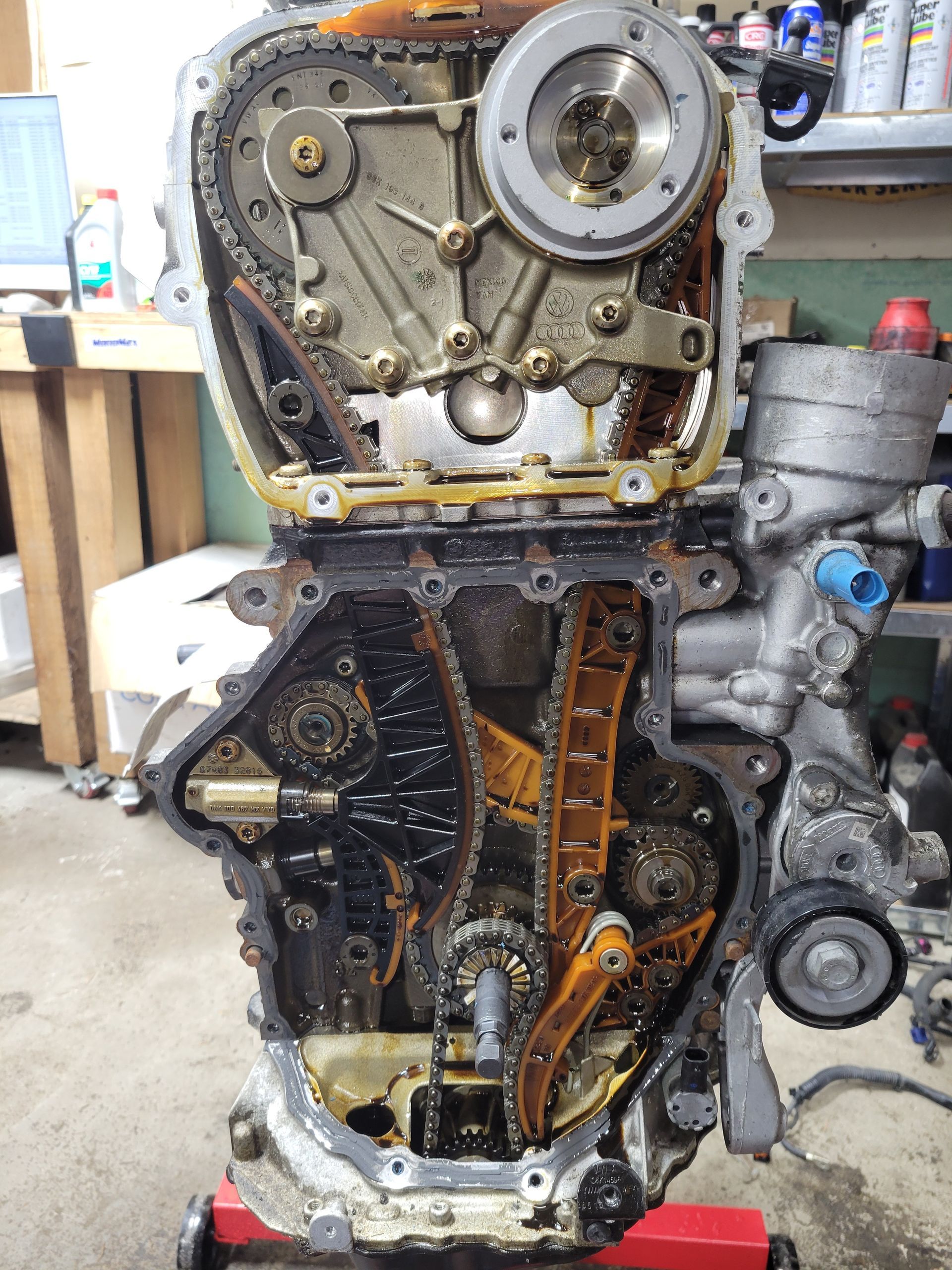 Open engine timing chain cover, showing chains, gears, and engine components. | Countryside Automotive