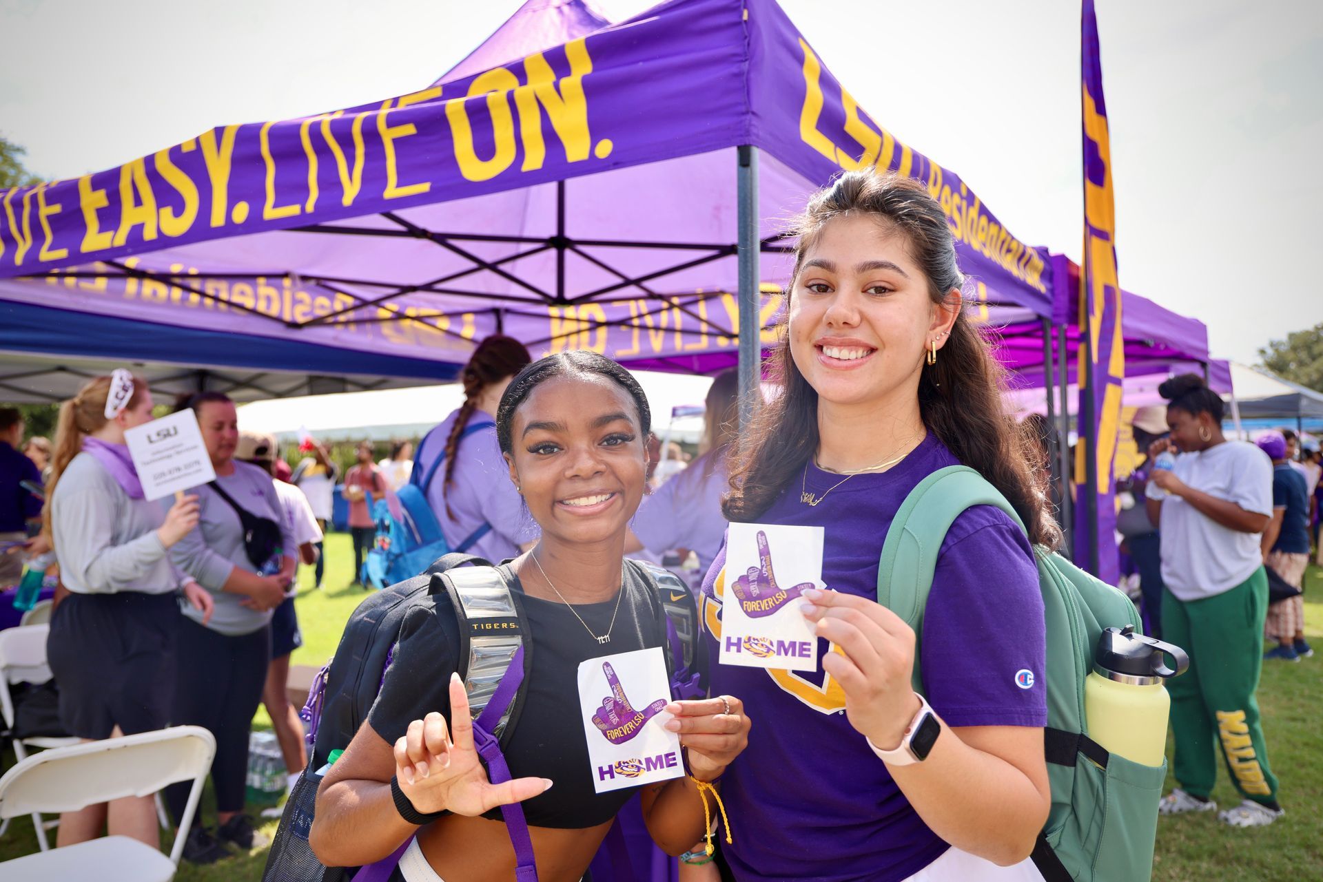 Two smiling people in purple shirts at a purple booth with a banner reading “EASY. LOVE. FUN.”
