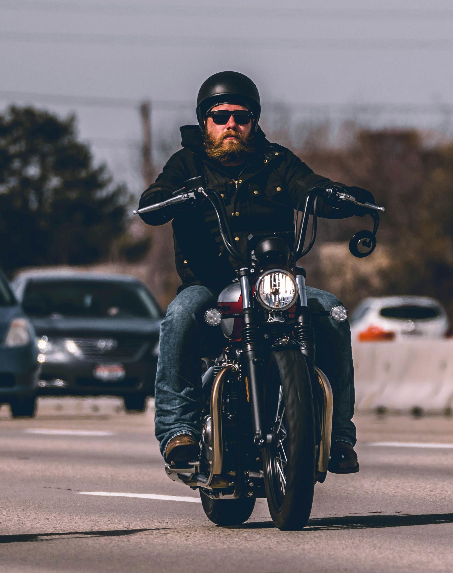 A man is riding a motorcycle down a street.