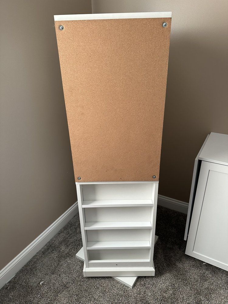 A white shelf with shelves is sitting on the floor in a room.
