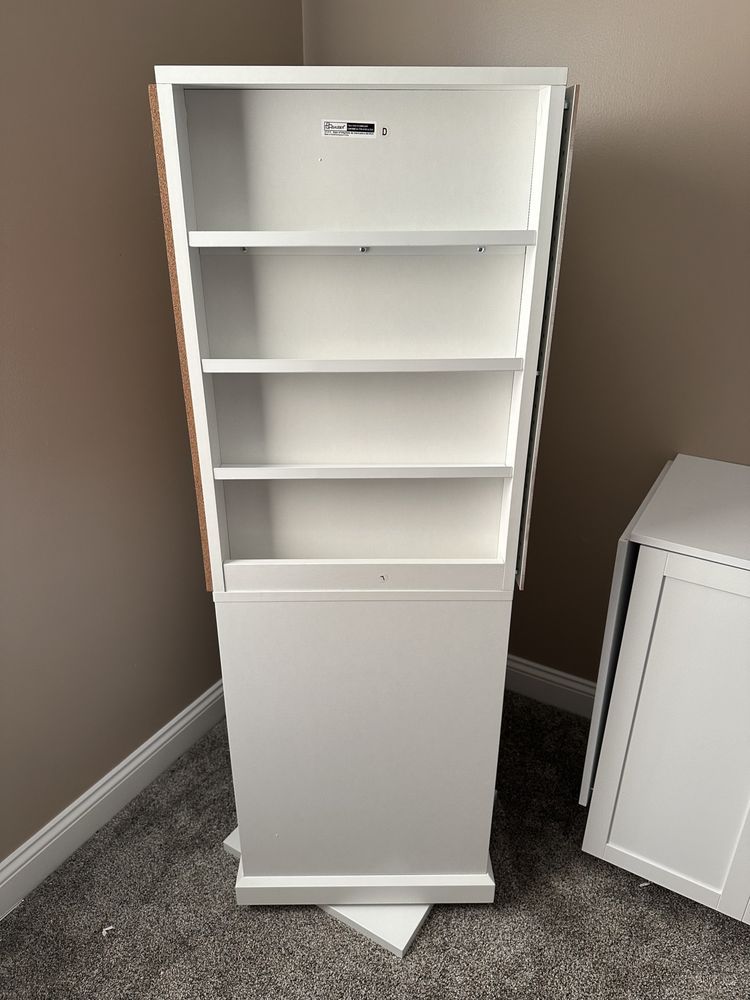 A white bookshelf is sitting on the floor in a room.
