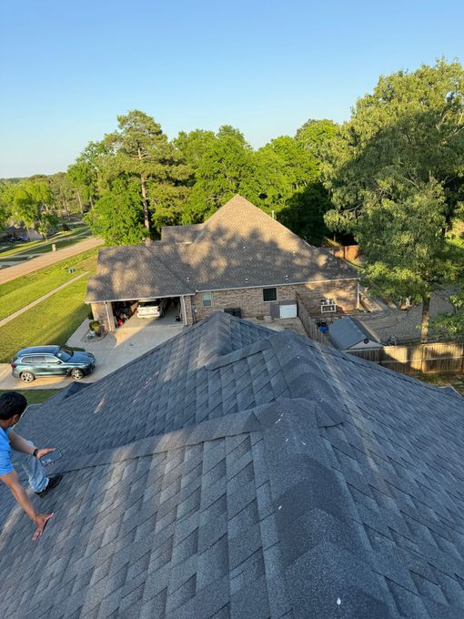 A man is standing on the roof of a house.
