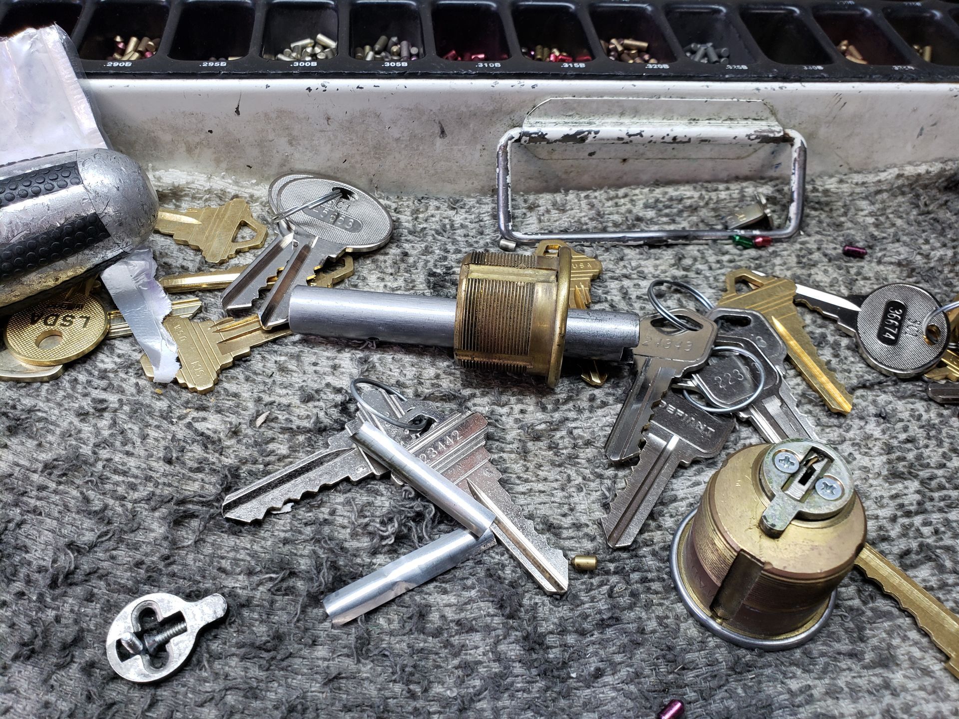 A bunch of keys are laying on a table and one of them has the letter g on it