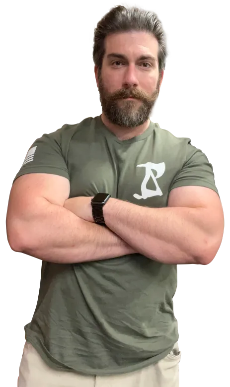 Man with crossed arms, wearing green t-shirt and smartwatch. Graying beard and serious expression. 