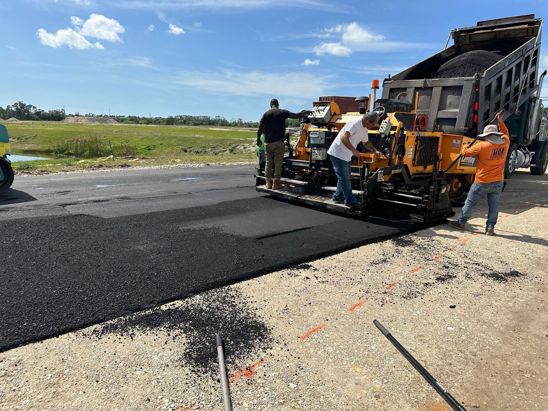 A group of construction workers are working on a road.