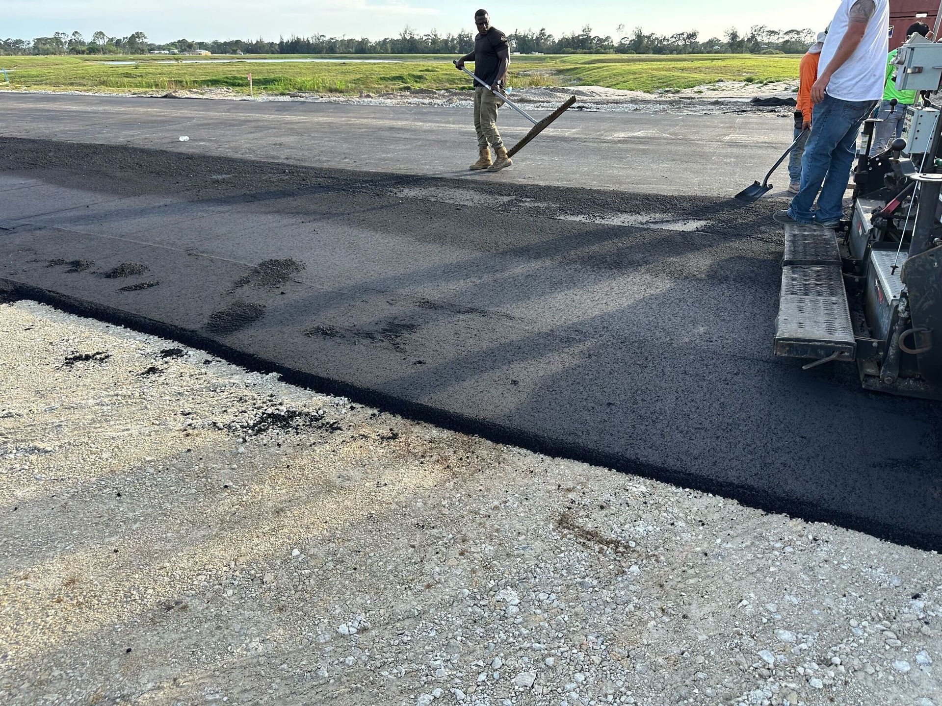 A group of men are laying asphalt on a road.