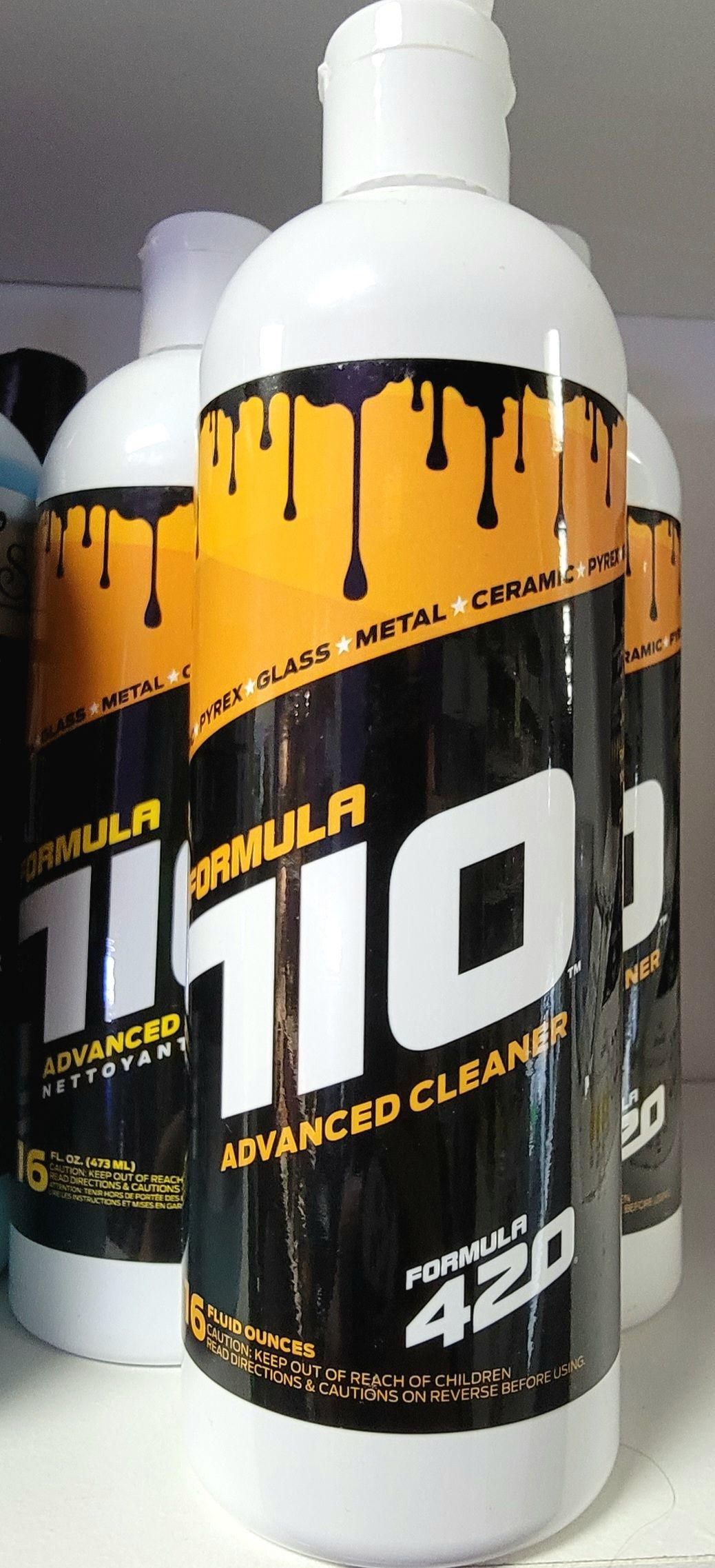 Bottles of Formula 420 cleaner. White bottles with black and orange labels, and a white cap.