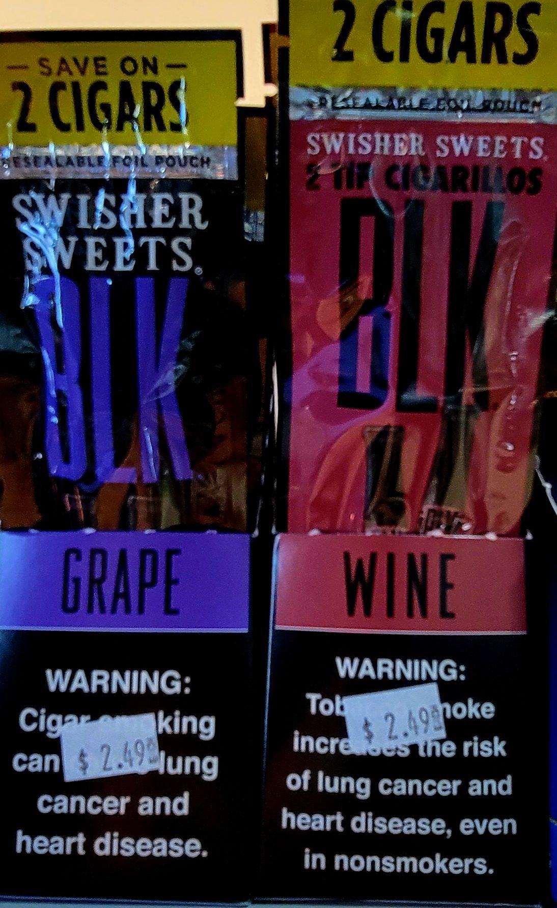 Two packs of Swisher Sweets cigars, grape and wine flavors, with health warnings.