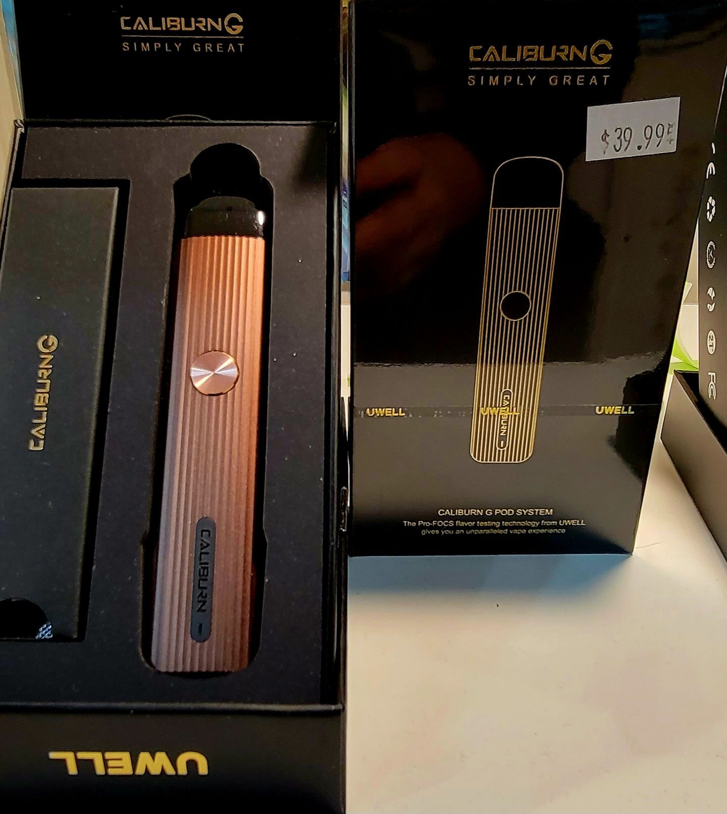 Uwell Caliburn G vape pen in its box. Copper-colored device, black packaging, $31.99 price tag.
