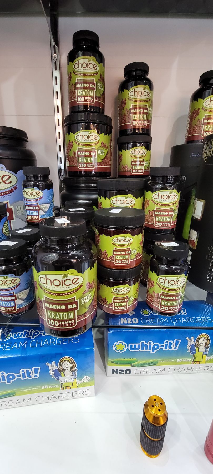 Various containers of health supplements on shelves and boxes. Some containers stacked on top of each other.