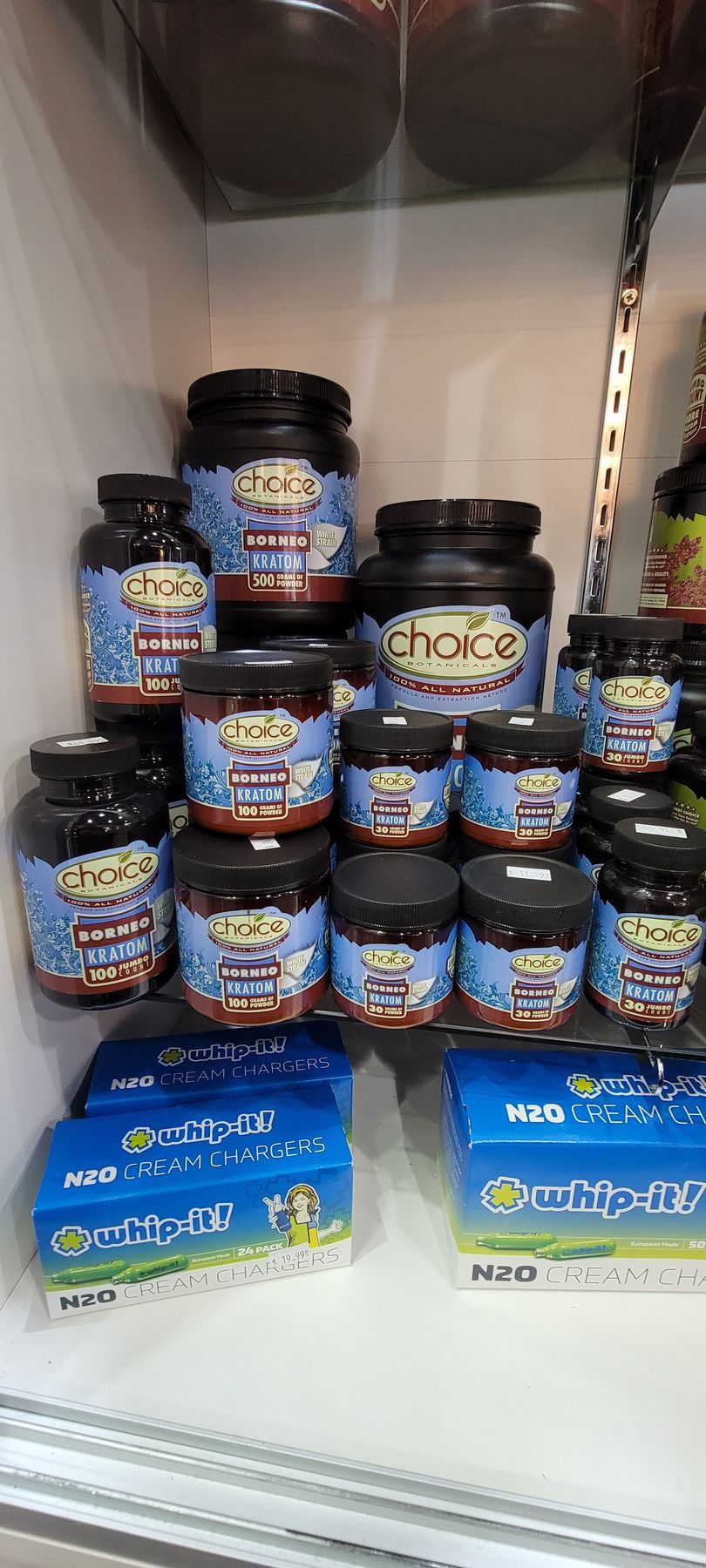 Shelves stocked with Choice brand supplements, various sizes of jars and boxes, blue and black packaging.